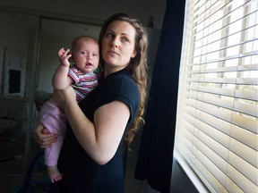 Naomi Baker holds her three-month-old daughter Faith in their Langley condo. Baker says second-hand smoke from a neighbour has plagued her family for two years.