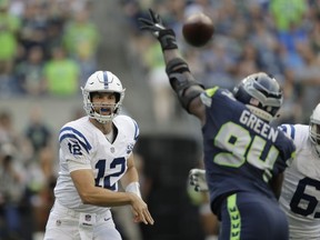 Indianapolis Colts quarterback Andrew Luck (12) passes through the defense of Seattle Seahawks defensive end Rasheem Green during the first half of an NFL football preseason game, Thursday, Aug. 9, 2018, in Seattle.