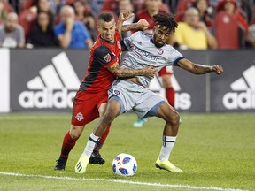 Toronto FC's Sebastian Giovinco, left, battles for the ball with Chicago Fire's Raheem Edwards, right, during the second half of MLS soccer action in Toronto, Saturday July 28, 2018. The Vancouver Whitecaps won't have to worry about the Atomic Ant in the first leg of the Canadian Championship final.