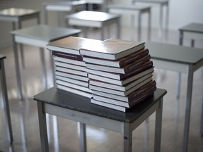 FILE PHOTO: Books are piled onto a desk in a empty classroom at McGee Secondary school in Vancouver, B.C. Friday, Sept. 5, 2014.
