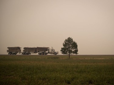 Thick smoke from wildfires fills the air as a logging truck carrying a load of timber travels on Hwy. 27 between Vanderhoof and Fort St. James, B.C., on Wednesday, August 15, 2018. The British Columbia government has declared a provincial state of emergency to support the response to the more than 500 wildfires burning across the province.