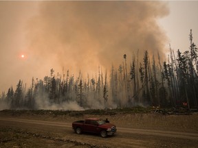 Verne Tom stops to check on a wildfire burning on a logging road approximately 20km southwest of Fort St. James, B.C., on Wednesday, August 15, 2018. The British Columbia government has declared a provincial state of emergency to support the response to the more than 500 wildfires burning across the province.