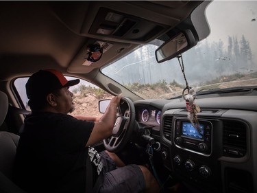 Verne Tom drives on a logging road to check on a wildfire burning approximately 20km southwest of Fort St. James, B.C., on Wednesday, August 15, 2018. The British Columbia government has declared a provincial state of emergency to support the response to the more than 500 wildfires burning across the province.