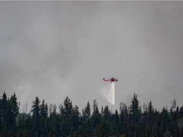 A helicopter drops water on a wildfire burning near Fraser Lake, B.C., on Wednesday August 15, 2018. The British Columbia government has declared a provincial state of emergency to support the response to the more than 500 wildfires burning across the province.