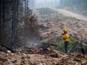Firefighter Christian Garcia, of Mexico, puts out hot spots in an area burned by the Shovel Lake wildfire near Endako, B.C., on Thursday, August 16, 2018.