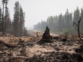 Firefighters direct water on hotspots last week in an area burned by the Shovel Lake wildfire near Endako, B.C. The Shovel Lake wildfire is more than 680 square kilometres in size and is the largest of the more than 500 fires burning across the province.