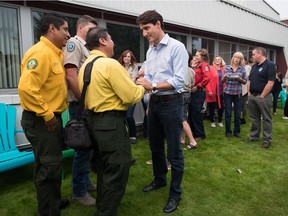 Prime Minister Justin Trudeau, centre, speaks with Alfredo Nolasco, second left, Fire Handling Manager of MexicoÕs National Forest Commission (CONAFOR), as Miguel Campos, left, a representative of CONAFOR listens, during a visit to the Prince George Fire Centre, in Prince George on Thursday August 23, 2018.