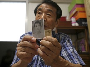 In this Aug. 17, 2018, photo, Lee Soo-nam, 76, shows photos of his brother Ri Jong Song in North Korea during an interview at his home in Seoul, South Korea. Lee is among about 200 war-separated South Koreans and their family members who are crossing into North Korea for heart-wrenching meetings with relatives they haven't seen for decades. The week-long event beginning Monday, Aug. 20, 2018, at North Korea's Diamond Mountain resort come as the rival Koreas boost reconciliation efforts amid a diplomatic push to resolve the North Korean nuclear crisis.