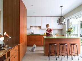 Home owner Joelle Bradley and her dog Mae love the breezy galley kitchen reno with its easy access through Nano doors to the outside terrace. The original ‘60s chandelier over the avocado quartz and cherrywood island is made of smoked acrylic plastic circles. It’s one of several original vintage lighting fixtures discovered in the house.