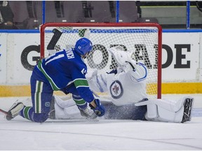 Winnipeg Jets goaltender Mikhail Berdin makes a save on Vancouver Canucks left winger Jonah Gadjovich during the Young Stars Classic at the South Okanagan Events Centre.