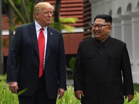 (FILES) In this file photo taken on June 11, 2018 North Korea's leader Kim Jong Un (R) walks with US President Donald Trump (L) during a break in talks at their historic US-North Korea summit, at the Capella Hotel on Sentosa island in Singapore.