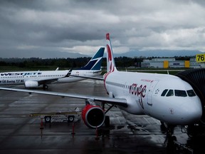 A Westjet Boeing 737-800, left, taxis past an Air Canada Rouge Airbus A319 at Vancouver International Airport in Richmond on April 28, 2014. The federal Competition Tribunal has set a date for hearings between the Vancouver Airport Authority and the Competition Bureau, which has accused the airport operator of imposing restrictions it says decrease competition among in-flight catering companies.