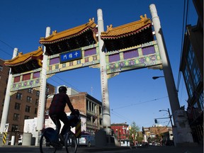 A cyclist rides under the Chinatown entrance in Vancouver.
