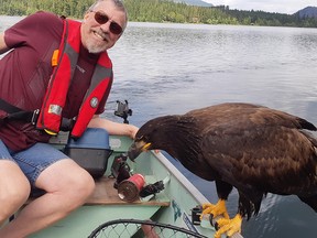 Derril McKenzie, a millwright from Kelowna, smiles into the camera, tilting to get both the eagle and him into the shot, seemingly unfazed while fishing in the waters of Gardom Lake just outside of Salmon Arm on Friday Aug. 31, 2018.