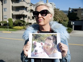 Holly Wood holds a photo of her late daughter Amora and dog Ceely in front of the West Vancouver apartment building where she last saw the dog.