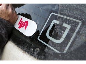 FILE- In this Jan. 31, 2018, file photo, a Lyft logo is installed on a Lyft driver's car next to an Uber sticker in Pittsburgh. The "gig" economy might not be the new frontier for America's workforce after all. From Uber to Lyft to TaskRabbit to YourMechanic, so-called gig work has been widely seen as ideally suited for people who want the flexibility and independence that traditional jobs don't offer. Yet the evidence is growing that over time, they don't deliver the financial returns many expect.