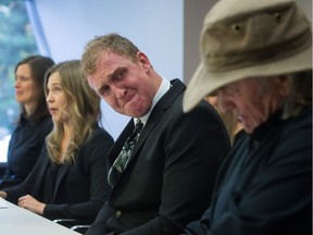 FILE PHOTO: Peter de Groot's brother Miles de Groot, centre, fights back tears as he looks at his father Peter de Groot Sr., right, while his sister Danna de Groot, second left, reads a statement during a news conference in Vancouver, B.C., on Monday October 20, 2014. Forty-five-year-old Peter de Groot, the subject of a police manhunt in southern British Columbia earlier this month was killed by members of the RCMP's emergency response team.