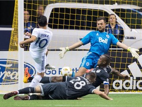 San Jose Earthquakes' Jahmir Hyka (10) is stopped by Vancouver Whitecaps goalkeeper Stefan Marinovic, back right, as Kendall Waston and Jake Nerwinski (28) defend during the second half of an MLS soccer game in Vancouver, on Saturday September 1, 2018.