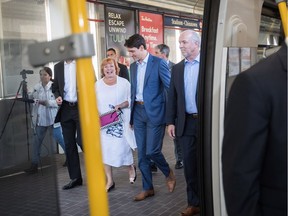 Surrey Mayor Linda Hepner, Prime Minister Justin Trudeau and Premier John Horgan prepare to ride SkyTrain to their news conference on Tuesday. But the soaring costs of the two projects suggest it is that taxpayers that are being taken for a ride, says columnist Vaughn Palmer.