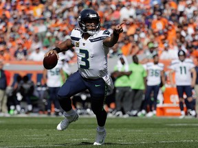In this Sunday, Sept. 9, 2018, file photo, Seattle Seahawks quarterback Russell Wilson looks before throwing a pass during the first half of an NFL game against the Denver Broncos in Denver.