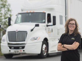 Truck driver Vivienne Carbonneau poses next to her rig in Vaudreuil-Dorion, Que., on Aug. 27, 2018.