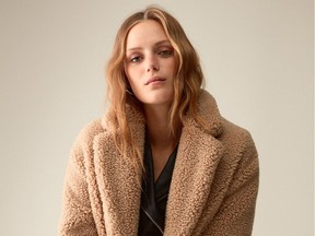 The ultimate cool-girl topper this season is a faux-fur or sherpa coat. A model wears the Wilfred Free Teddy Cocoon coat from Aritzia, $228.