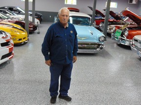 Garry Cassidy in the newly-rebuilt shop with some of the collector cars replacing those lost in last year’s fire.
