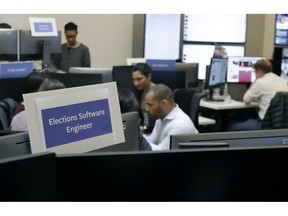 Workers gather and sit and their desks during a demonstration in the war room, where Facebook monitors election related content on the platform, in Menlo Park, Calif., Wednesday, Oct. 17, 2018.