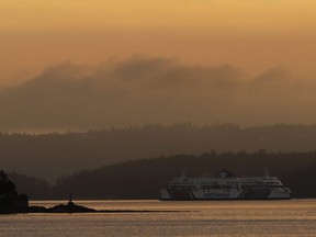 In this Sept. 25, 2018 photo, a BC Ferries boat sails near Vancouver Island, British Columbia, at sunrise.