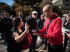 A woman opposed to marijuana use, left, argues with Anil Sthankiya, right, managing editor of POT TV, on the day recreational cannabis became legal, in Vancouver, on Wednesday October 17, 2018.