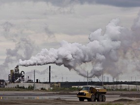 A dump truck works near the Syncrude oil sands extraction facility near the city of Fort McMurray, Alta., on June 1, 2014. Canadians will find out Tuesday exactly how they will be compensated for the upcoming federal carbon tax.