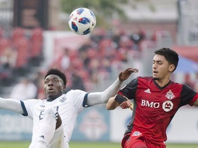 Vancouver Whitecaps forward Alphonso Davies, left, battles for the ball giants Toronto FC midfielder Marco Delgado (18) during first half MLS soccer action in Toronto on October 6, 2018. Some familiar faces will be missing from the lineup Wednesday when the Vancouver Whitecaps host Sporting Kansas City in another crucial battle. Six of Vancouver's usual starters are off on international duty, but the 'Caps (12-12-7) need to win each of their final three regular season matches in order to secure a playoff berth.