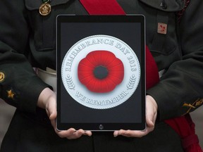 A cadet holds a tablet showing the digital poppy during a ceremony marking the start of the Canadian Legion's Remembrance Day poppies at the Beechwood National Memorial centre Monday, October 22, 2018 in Ottawa. The Remembrance Day poppy has entered the digital age. The Royal Canadian Legion launched a digital version of the distinctive red flower, which it says can be customized, shared online and used as a profile image on sites including Facebook, Twitter, Instagram and LinkedIn.
