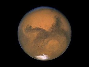 This Aug. 26, 2003 image made available by NASA shows Mars photographed by the Hubble Space Telescope on the planet's closest approach to Earth in 60,000 years. Research is debunking old theories about how Mars got its moons. Chris Herd, co-author of a newly published paper, says scientists used to believe that Deimos and Phobos were once asteroids. THE CANADIAN PRESS/AP, NASA