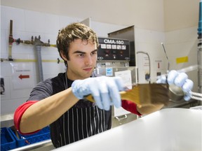 Dishwasher and baker's assistant Alex Lecce places clean dishes in a bin at the washing station at Gabi & Jules Handmade Pies.