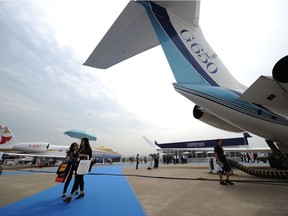 A visitor walks underneath a Gulfstream aircraft at Hongqiao Airport in Shanghai on April 16, 2013.