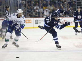 Winnipeg Jets' Blake Wheeler (26) works his way around Vancouver Canucks' Alexander Edler (23) during second period NHL action in Winnipeg on Thursday, October 18, 2018.