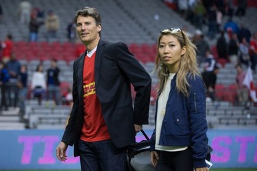 Vancouver Mayor Gregor Robertson and singer-songwriter Wanting Qu leave the field after Robertson presented the man of the match award after Canada and Japan played a rugby test match in Vancouver on June 11, 2016.