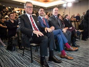 LNG Canada CEO Andy Calitz, front left to right, Prime Minister Justin Trudeau and B.C. Premier John Horgan sit together during an LNG Canada news conference in Vancouver on Oct. 2, 2018. LNG Canada announced that its joint-venture participants Shell, PETRONAS, PetroChina, Mitsubishi Corp. and KOGAS made a final investment decision to build the LNG Canada export facility in Kitimat.
