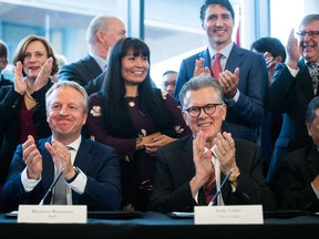 Shell Integrated Gas & New Energies Director Maarten Wetselaar, front left, LNG Canada CEO Andy Calitz, front right, and Prime Minister Justin Trudeau, back right, applaud after a final investment declaration was signed by LNG Canada joint venture participants to build an LNG export facility in Kitimat, during a news conference in Vancouver on Tuesday, Oct. 2, 2018.