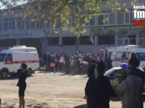 In this image made from video, showing the scene as emergency services load an injured person onto a truck, in Kerch, Crimea, Wednesday Oct. 17, 2018. An explosive device has killed several people and injured at least 50 others at a vocational college in Crimea Wednesday in what Russian officials have called a possible terrorist attack. (Kerch FM News via AP) KERCH.FM LOGO CANNOT BE OBSCURED