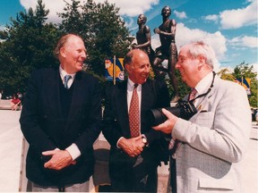 Roger Bannister (left), John Landy and photographer Charlie Warner in front of the statue based on Warner's photo at Hastings and Renfrew in 1994.