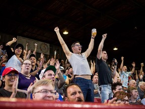 Fans cheer during the Vancouver Canadians and Tri-City Dust Devils baseball game at Nat Bailey Stadium in Vancouver, British Columbia on August 15, 2018. Nat Bailey Stadium in Vancouver, BC is home to the Vancouver Canadians minor league baseball team.