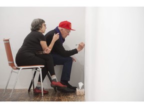 Garry Neil Kennedy drawing names on the wall of CSA Space with assistant Dorit Cypis on Friday, Oct. 26.