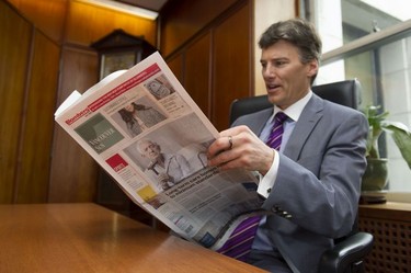 Mayor Gregor Robertson at City Hall reads the new look Vancouver Sun on April 5, 2016.