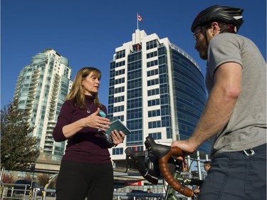 Candidate for mayor of Vancouver Shauna Sylvester talks with a cyclist as she campaigns at Quebec and Terminal on Oct. 19, 2018.