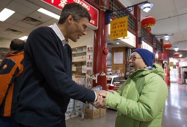 Vancouver Mayor Gregor Robertson greets a woman while campaigning in Chinatown on Thursday Nov. 13, 2014.