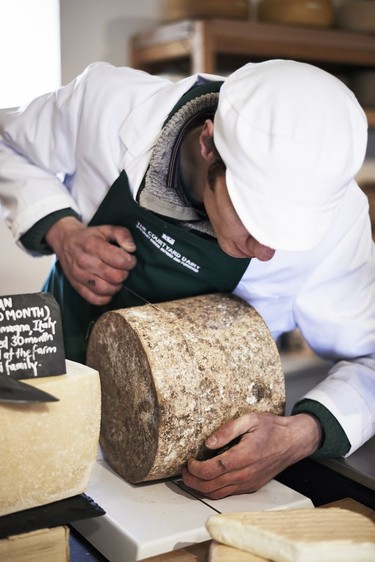 Andy Swinscoe cuts some cheese inside The Courtyard Dairy in Settle.