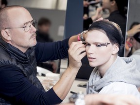 Peter Philips, creative image director of Dior Makeup, works on a model backstage in this 2018 handout photo.