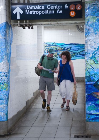 A couple of travellers consult  their New York city subway map.